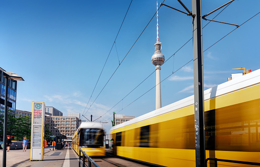 motion blurred yellow cable cars approaching station berlin Alexanderplatz from opposite directions
