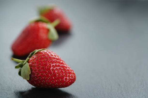 ripe organic strawberries on slate background, with copy space
