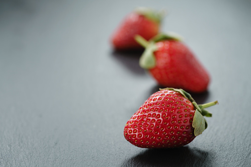 ripe organic strawberries on slate background, with copy space