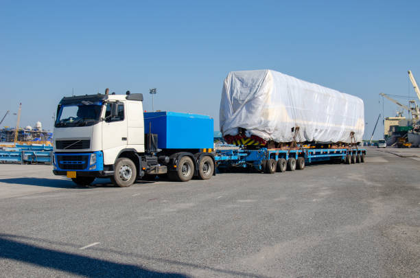 Unloading operation of project  cargo with port heavy lift cranes A crane on a large cargo ship docks loading a diesel-electric locomotive.  at Laem Chabang Port