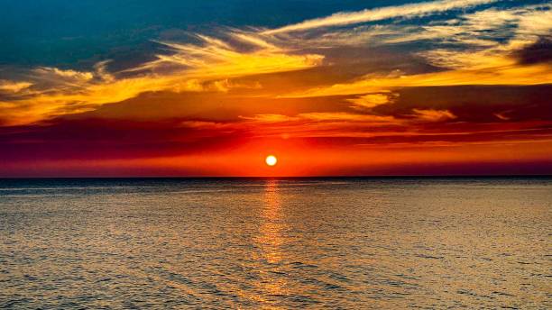 istock Beautiful sunset  illuminating the sky above a water 1500882170