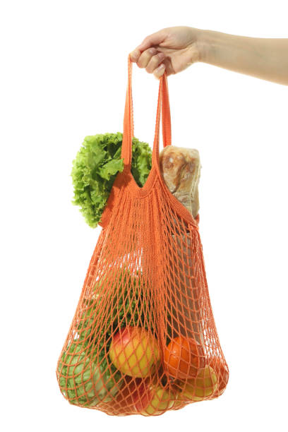 istock Female hand holds string bag with grocery, isolated on white background 1500884883