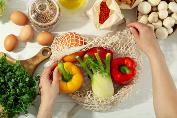 istock Female hands get food from string bag on white wooden table 1500885958