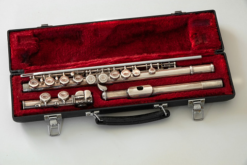 old flute inside a padded red case