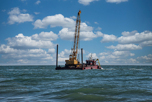 barge for transporting large rocks for the construction of breakwaters to protect beaches from the action of waves and high tides.