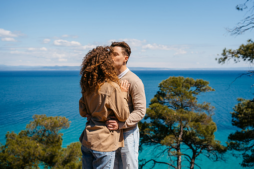 Beautiful young couple kissing by the sea at Greece.