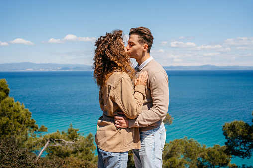 Beautiful young couple kissing by the sea at Greece.