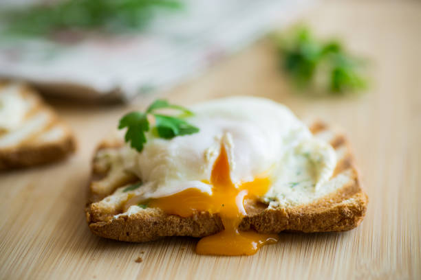 istock Fried toast bread with spread and poached egg, on a wooden table. 1500895585