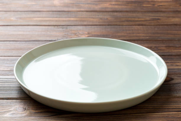 istock Perspective view of empty blue plate on wooden background. Empty space for your design 1500897054