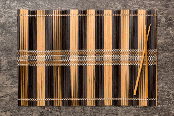 istock Two chopsticks and bamboo mat on cement background. Top view, copy space 1500897140