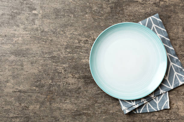 istock Top view on colored background empty round blue plate on tablecloth for food. Empty dish on napkin with space for your design 1500897158