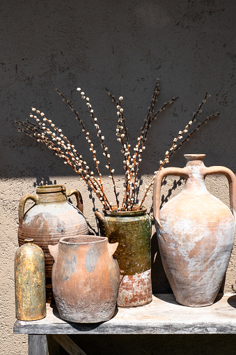 A large old terracotta amphora is used as a flower pot. Street decoration example