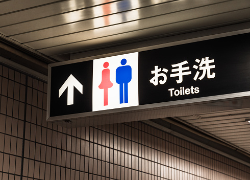 A female and male symbol next to the Japanese for 'rest room', and the word 'toilet' in English.