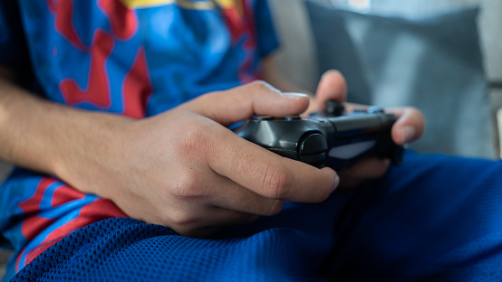 Close-up young man holding game console at home