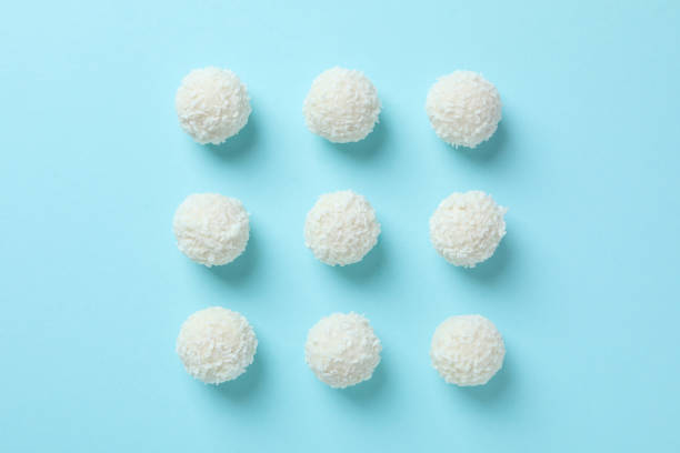 Flat lay with coconut candies on blue background