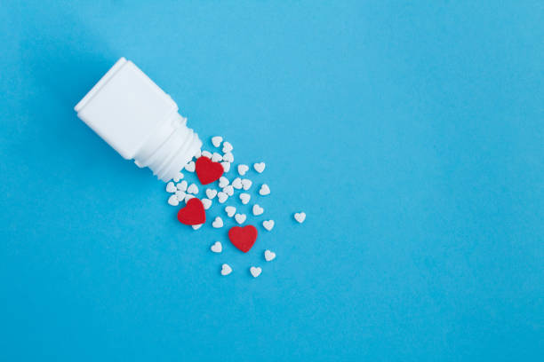 istock White bottle with heart shaped pills on the blue background. Top view. Copy space. 1500912045