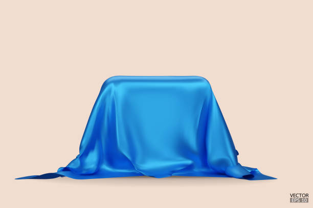 istock Podium covered with a piece of blue silk isolated on beige background. Realistic box covered with blue cloth. Podium for product, cosmetic presentation. Creative mock up. 3d vector illustration. 1500915565