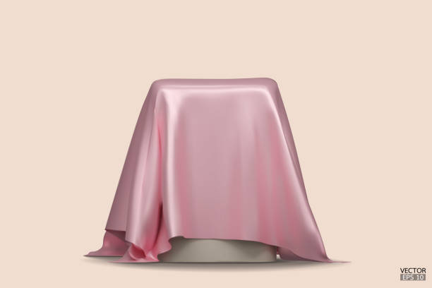istock Podium covered with a piece of light pink silk isolated on beige background. Realistic box covered with pink cloth. Podium for product, cosmetic presentation. Creative mock up. 3d vector illustration. 1500915883