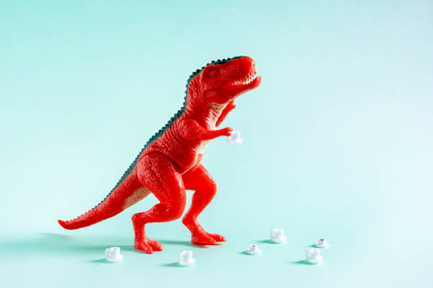 istock Red toy dinosaur with coffee cups on blue background. Coffee addiction concept. 1500917009