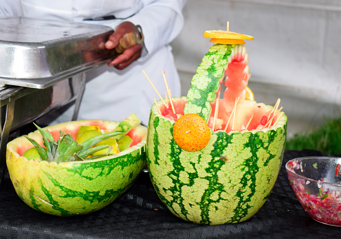 shot at an African wedding ceremony , the water melons were cut in  shapes of a bowl and a basket respectively.
