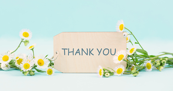Thank you card surrounded by flowers, being thankful, support, help and charity concept, positive attitude