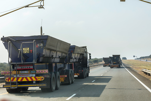 Mining ore transportation in large trucks on the highway in Rustenburg, South Africa