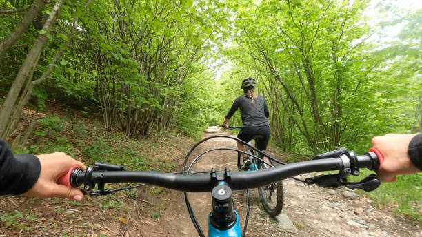 first person perspective following female biker ahead - journey footpath exercising effort imagens e fotografias de stock