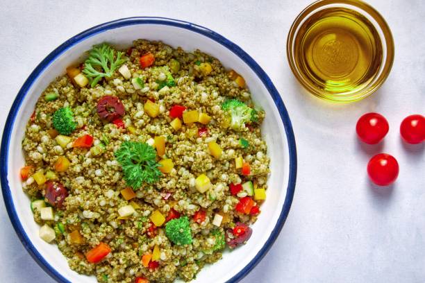 salade de quinoa dans un bol en porcelaine - salade de quinoa aux légumes croquants photos et images de collection