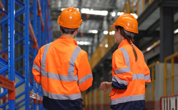 istock Engineer with orange safety jacket and PPE walk audit in factory and warehouse, back site of Wharehouse leader team walk audit , Industrial engineer discussing work in factory 1500948252