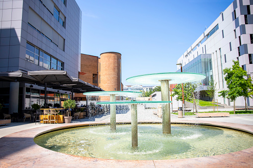 City fountain with water droplets in the business square district. Copy space