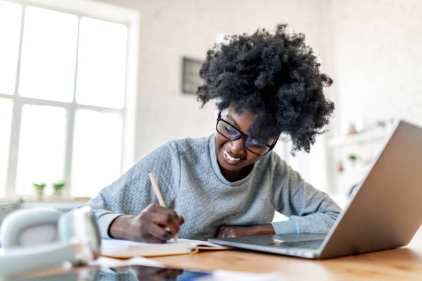 istock Young adult female student studying at college dorm using laptop 1500949284