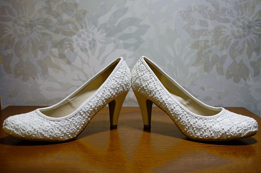 A pair of white wedding shoes in a classic stiletto-heel style, ready to complete the perfect bridal look