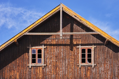 A close-up of wooden windows on the side of a large barn