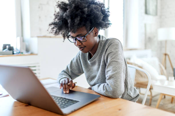 istock Young adult female student studying at college dorm using laptop 1500953310