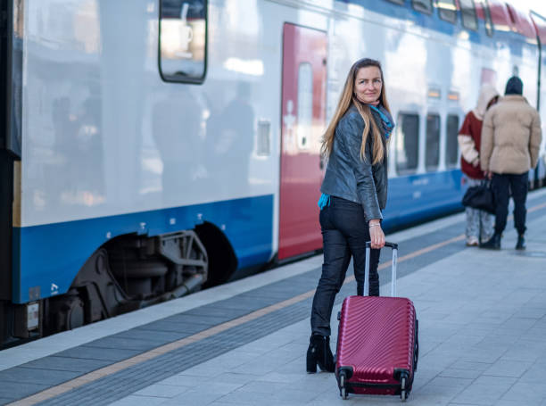 istock a woman with a suitcase next to a train 1500963034