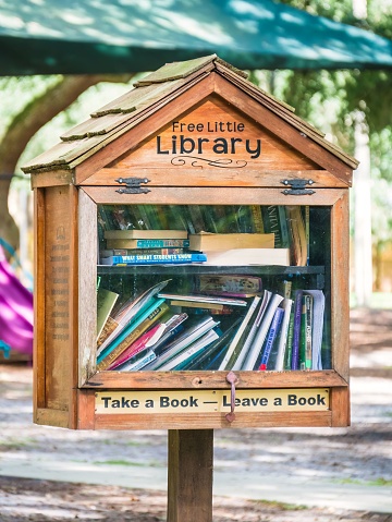 Winter Springs, United States – September 01, 2018: A small library and book stand that features a sign reading \