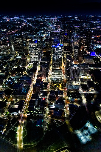 The illuminated streets and buildings of downtown Houston, Texas on an early spring evening just after sunset shot from an altitude of about 1000 feet directly over the city.