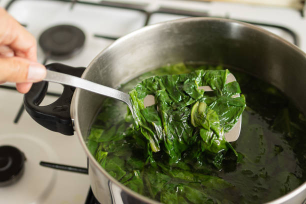 istock hand cooking boiled chard and spinach in a steaming pot on the stove 1500983129
