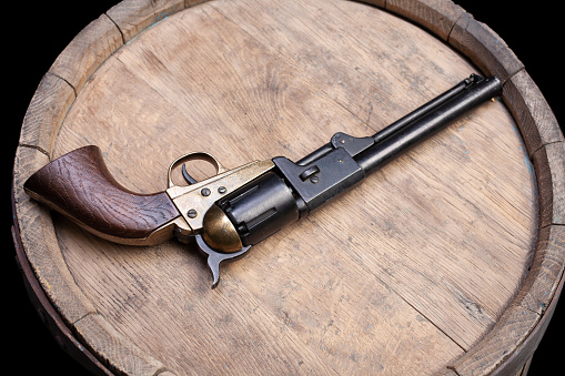 Old West Gun. Percussion Army Revolver on wooden barrel.