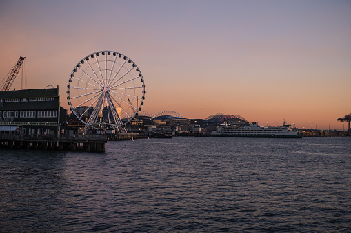 Seattle, USA - Feb 1, 2023: Late in the day the ferris wheel off pier 62 on the waterfront at sunset.