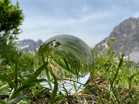 Lensball with grass reflections in the Austrian Alps, in the background the famous Rätikon Mountains (Montafon, Vorarlberg)