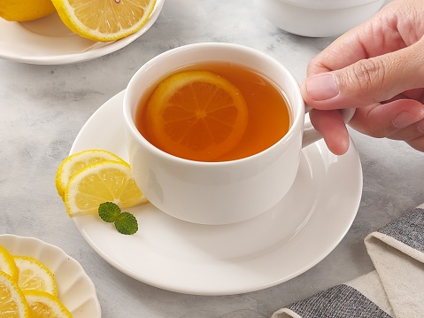 A cup of hot lemon tea. Isolated background in white