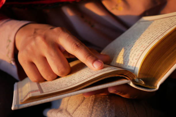 istock Muslim women's hand reading quran at night 1501022211