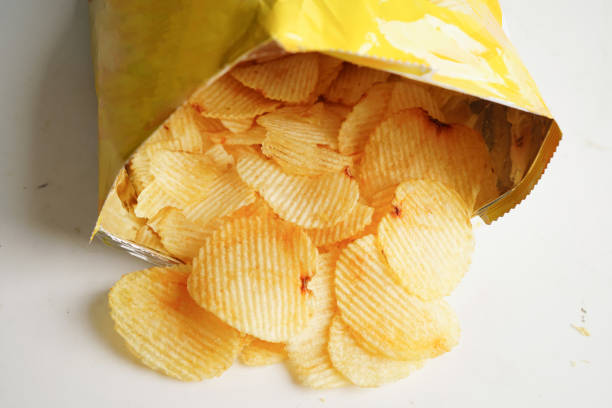 istock Potato chips in open bag, delicious BBQ seasoning spicy for crips, thin slice deep fried snack fast food. 1501027393