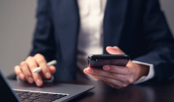 istock Businessman using smartphone and hand typing on the computer keyboard in the office. 1501028445