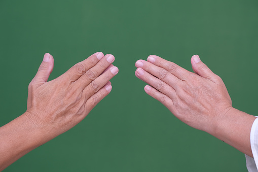 Close-up: The hands of a woman and a man signify to greet and forgive each other.