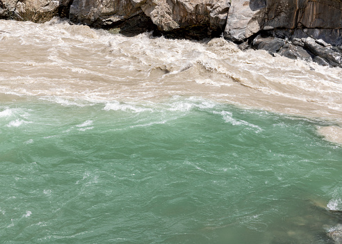 Meeting point of a green water and brown water in the river swat at bahrain valley, Pakistan