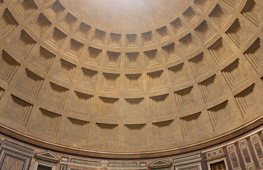 An impressive wide view inside the majestic Roman Pantheon, in the heart of Ancient Rome, with the central apse. Built in 27 BC by the Consul Marco Vispanio Agrippa for the Emperor Augustus and dedicated to all the Roman divinities, the majestic Pantheon is one of the best preserved Roman structures in the Eternal City and in the world. In addition, the Pantheon is also a Catholic church consecrated in 609 AD by Pope Bonficio IV and called the Basilica of Santa Maria ad Martyres. Within its perimeter some members of the Italian royal family and famous artists are buried, including the painter Raphael, a great protagonist of Renaissance art. The dome of the Pantheon, built in concrete and brick, is a masterpiece of engineering and the prototype of all the domes subsequently built in Christian churches in Europe. With a diameter of 43.44 meters, it is still the largest dome in the world today. In 1980 the historic center of Rome was declared a World Heritage Site by Unesco. Super wide angle image in High Definition format.
