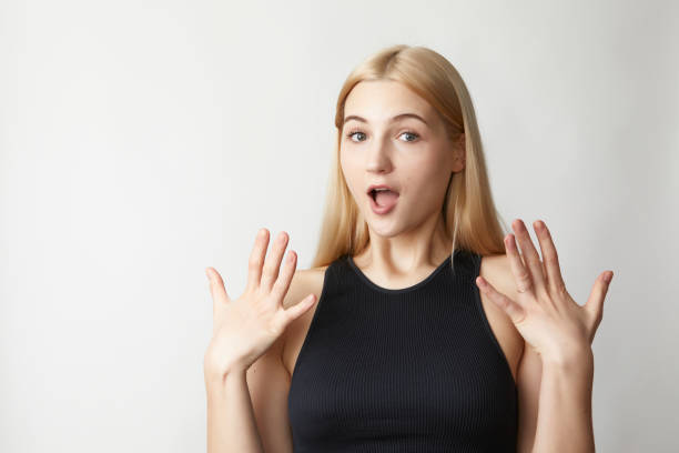 a cute pale skin long hair, 20 year old model acting surprised gestures and expressions in studio