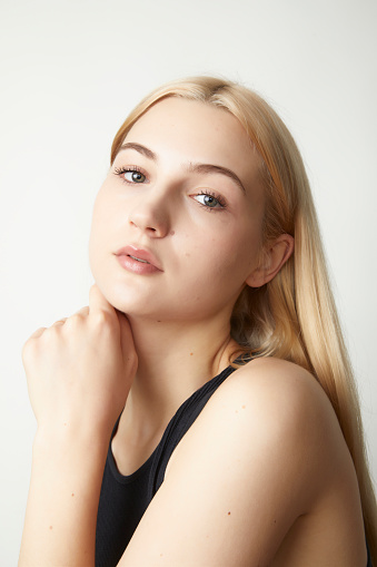 close-up portraits of pale skin long blonde haired fashion model in black gym suit with serious face